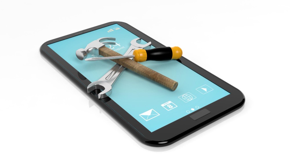 Phone on a white surface with a hammer and screwdriver on top to show Digital gated community helpdesk